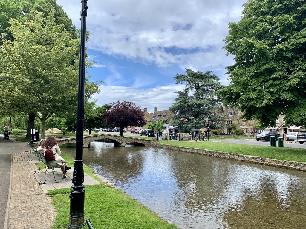 Beautiful view of the river, park, and a bridge in Bourton-on-the-Water, a Cotswolds Village