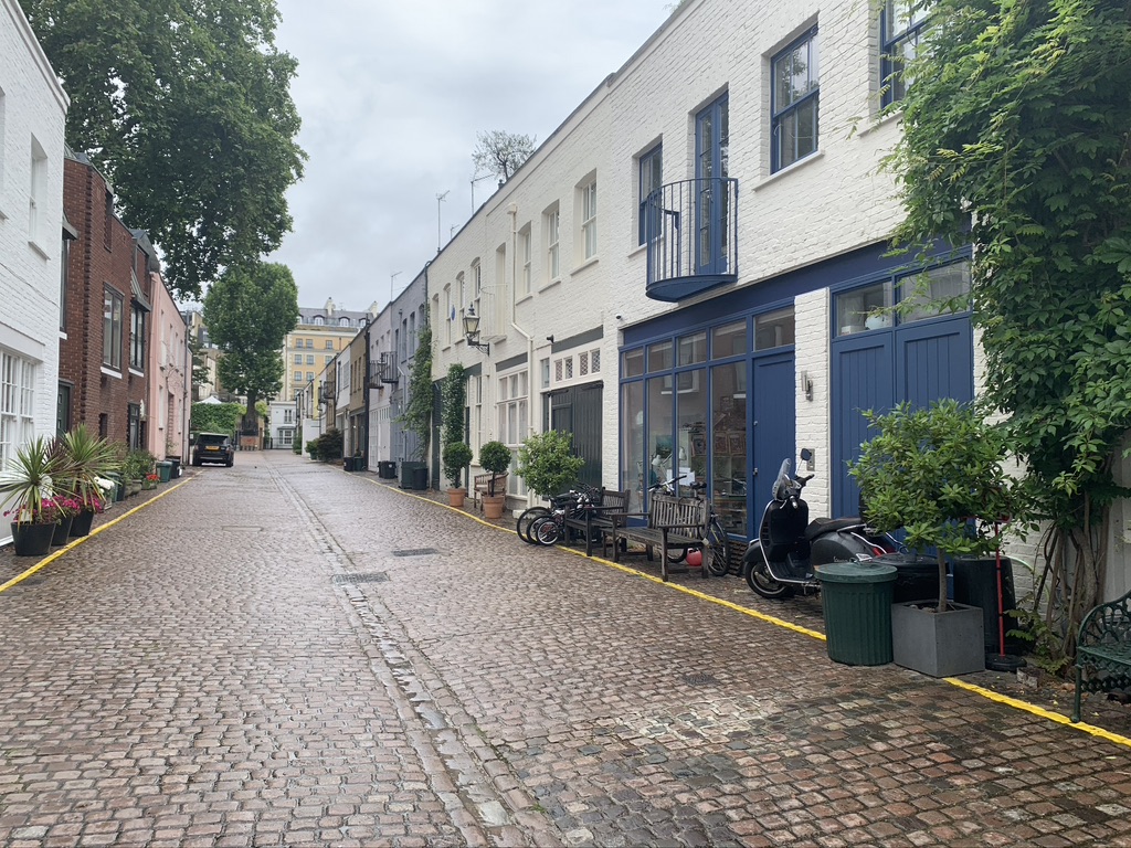 Mews in South Kensington, London is filled with colorful mews homes, green plants, and benches
