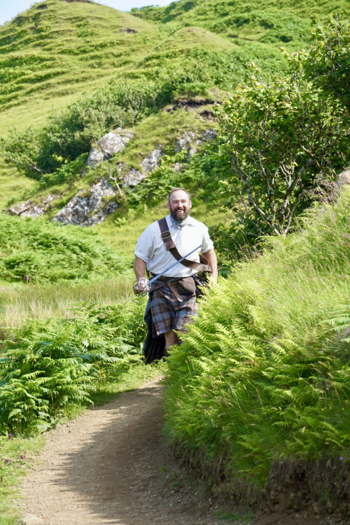 Andy the Highlander comes around the corner of the path at Castle Ewen