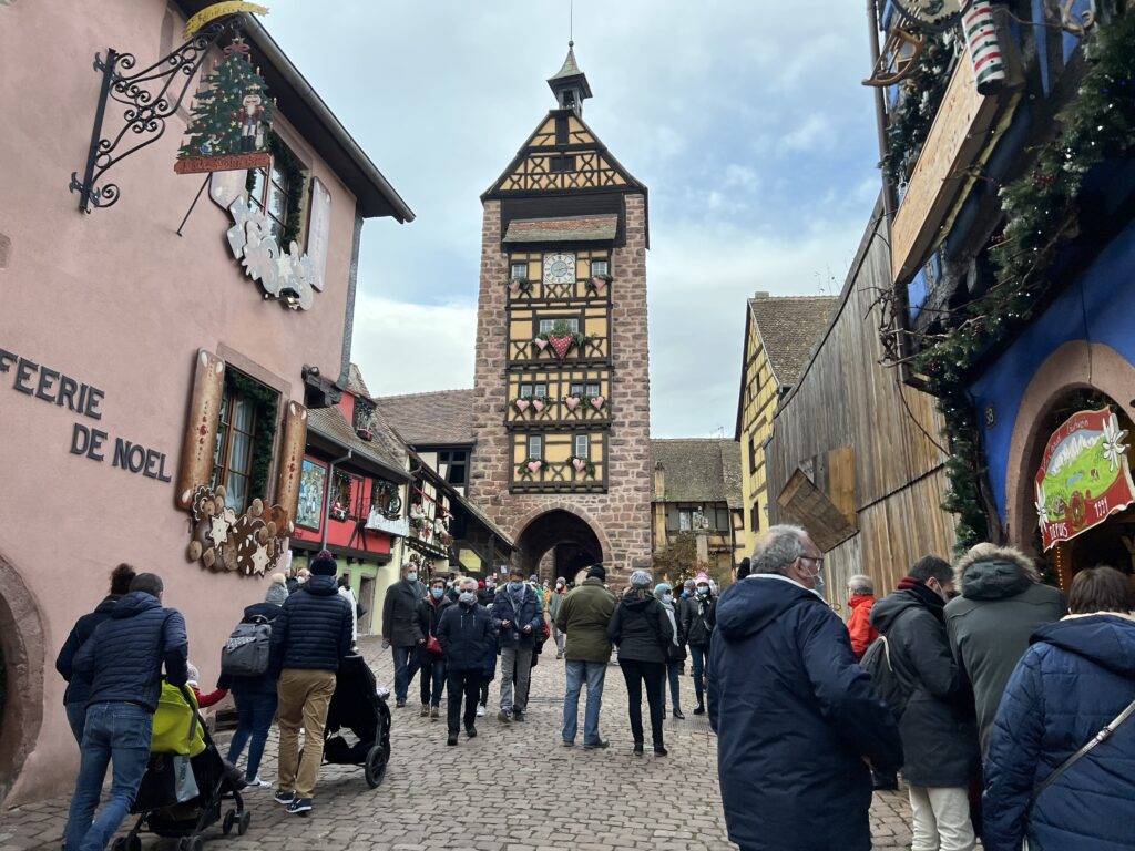 Beautiful Christmas decorations adorn the clock tower and surrounding buildings in Riquewihr, France