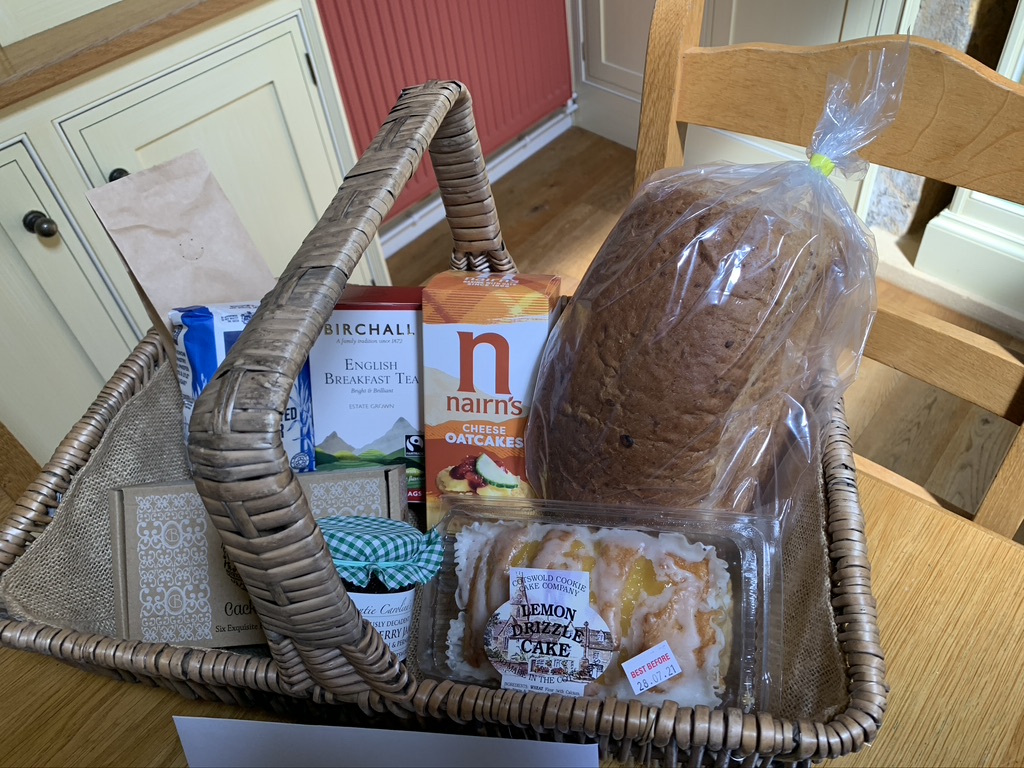 Basket of breakfast foods, including bread and a pastry treat.