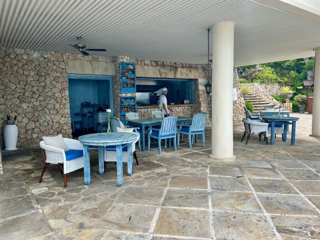 Resort poolside restaurant, with blue furniture and waiters waiting by the kitchen.