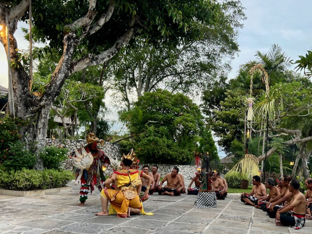 Traditional cultural dance of Bali at a resort in Jimbaran Bay. Two dancers dance to the beat singers