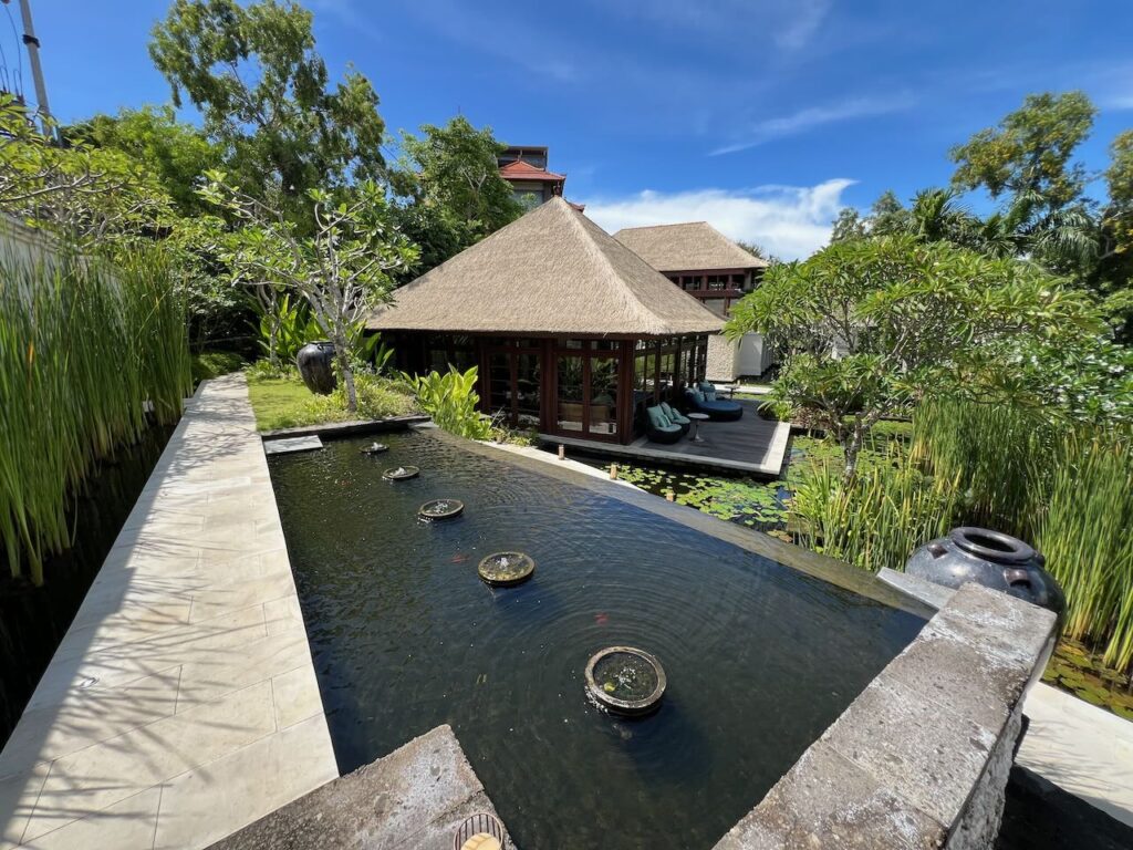 Lilypad pond looks out over a thatched roof building in Jimbaran Bay Bali.